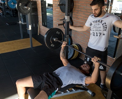 A young man determined to lifeting heavy in deep squatting position